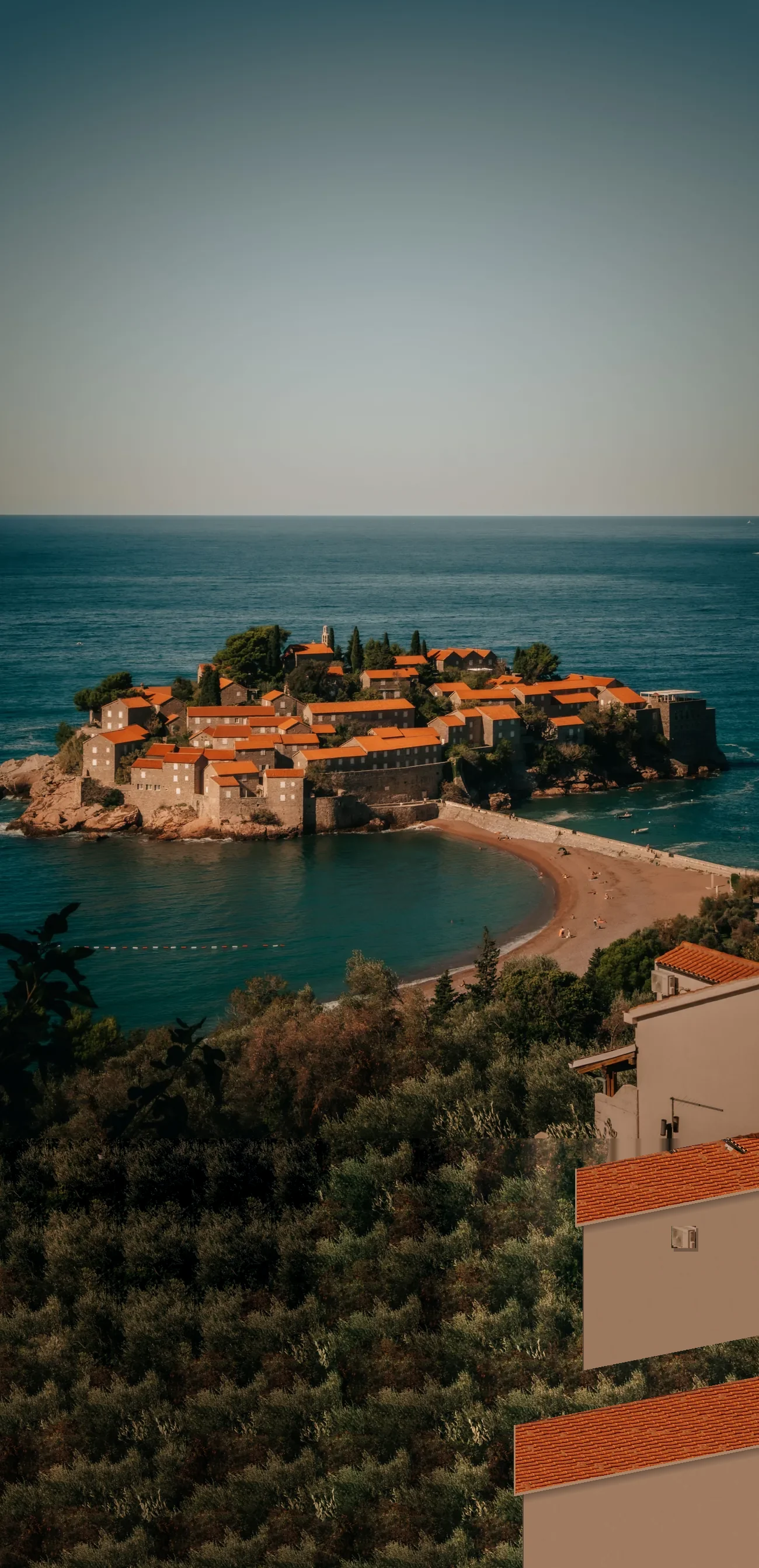 The island town of Sveti Stefan, red tiled roofs against the Adriatic